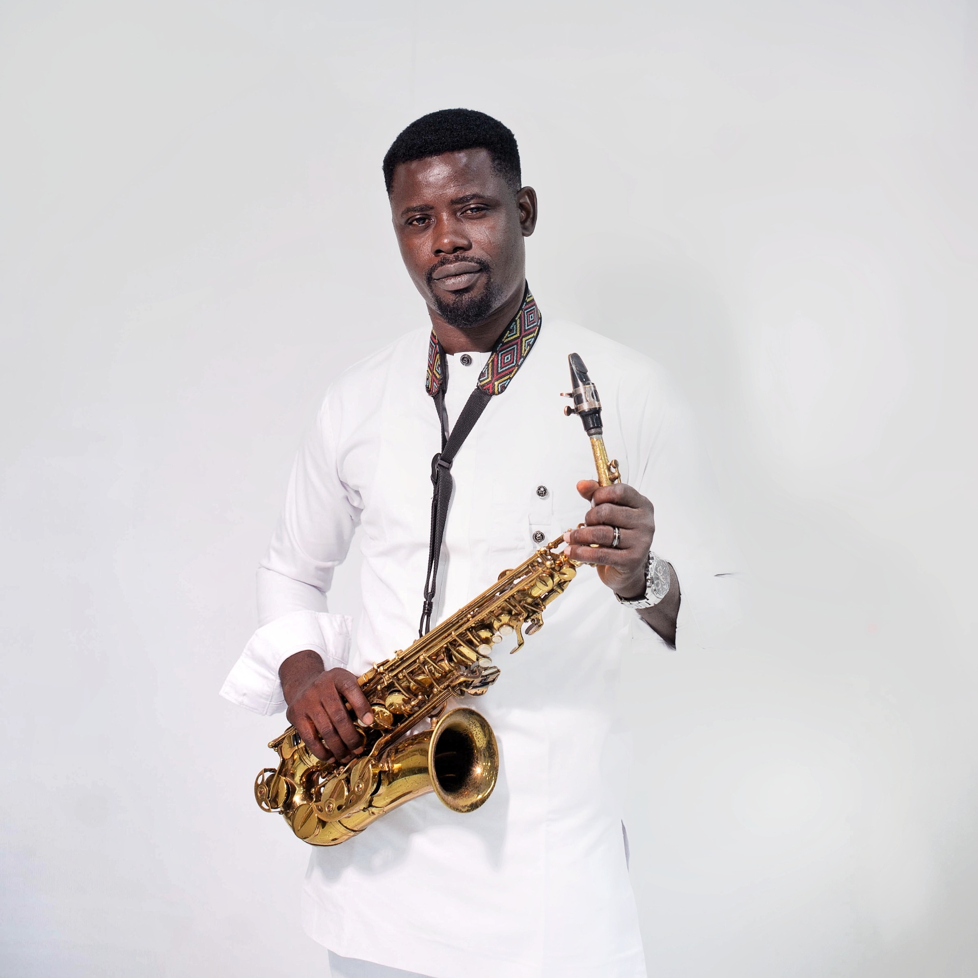 Big John in white traditional outfit with saxophone